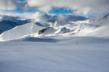 Alplerdeki kayak pistleri ve güzel kış manzaraları, Samnaun Ischgl, Tirol, Avusturya, bulutlar güneş ışığı ve mutluluk.