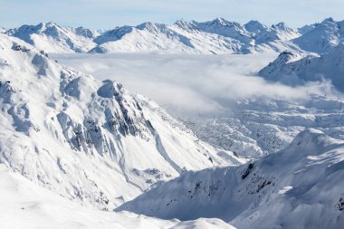 St. Anton am Arlberg yakınlarındaki Alpler 'de kayak pistleri ve güzel kış manzaraları. Bulutların üzerinde güneş ışığı var. Özgürlük kavramı, mutluluk, spor