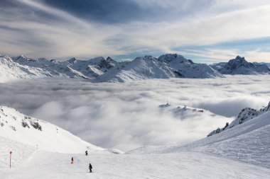 Kayak pistleri ve Alplerdeki güzel kış manzaraları, St. Anton am Arlberg, Vorarlberg yakınlarında, bulutların üzerinde güneş ışığı ile. Özgürlük kavramı, mutluluk, spor