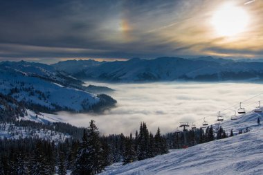 Alplerdeki güzel kış dağ manzarası, Kitzbuhel kayak alanı, Tyrol, Avusturya Günbatımı, bulutlar denizi, dağlarda huzurlu bir akşam..