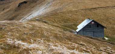 Kışın dağlarda küçük ahşap bir kulübe