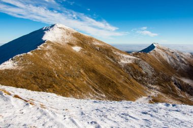 Taze karla kaplı güneşli dağ tepeleri.
