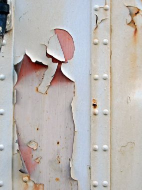 Paslı ve yıpranmış metal bir duvara yakın. 