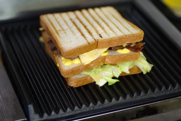Fresh Sandwich on the Grill. The process of making a fresh sandwich on the grill. Selective focus