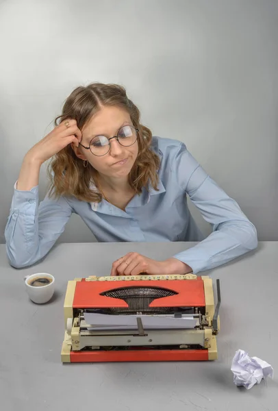 Girl - writer, red vintage typewriter and a cup of coffee on table