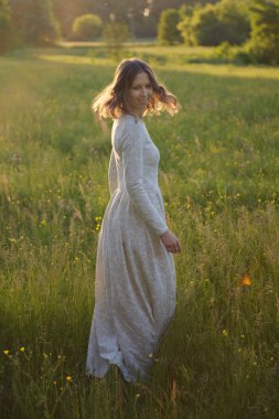 Gün batımında beyaz elbiseli güzel kız