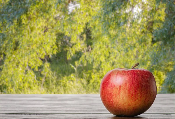 Mela Rossa Tavolo Con Sfondo Naturale — Foto Stock