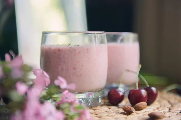 Dos Vasos Con Hermoso Batido Con Nueces Flores Sobre Mesa — Foto de Stock