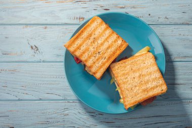 Mavi tabakta sebzeli sandviç