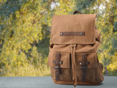 Doğal bir arka plan ile bir tabloda Vintage kahverengi sırt çantası