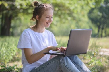 Kız ile bir dizüstü bilgisayar açık havada gülümseyen