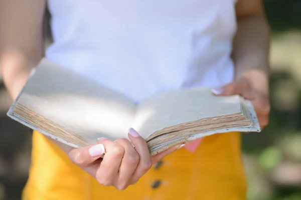 Open book in the hands of woman