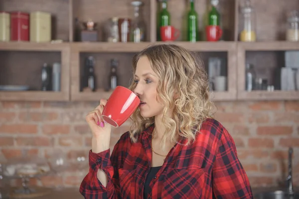 Girl drinking coffee in the kitchen