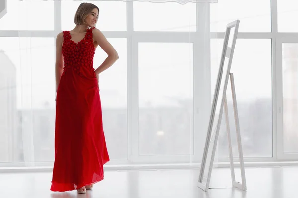Dziewczyna Czerwonej Sukience Wygląda Lustrze — Zdjęcie stockowe