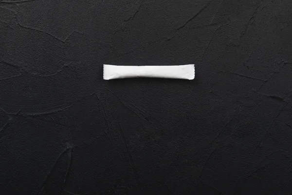 White bag of sugar on a black background