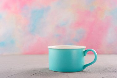 Parlak renkli arka plan ile masada Mavi fincan