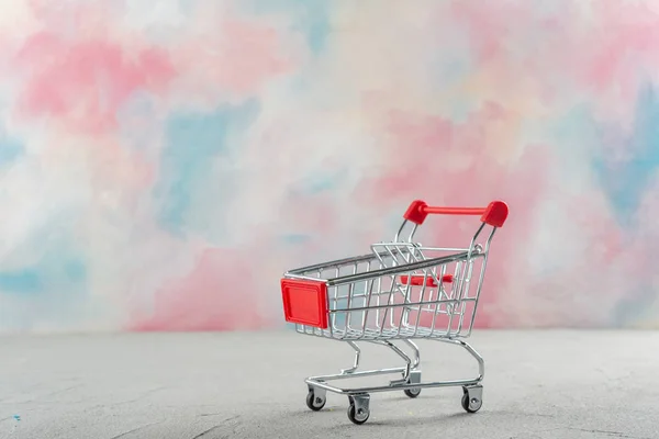 Supermarkt Einkaufswagen Auf Einem Farbigen Hintergrund Mit Einem Hintergrund Hellen — Stockfoto