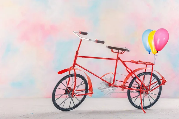 Bicycle with balloons with a bright color background
