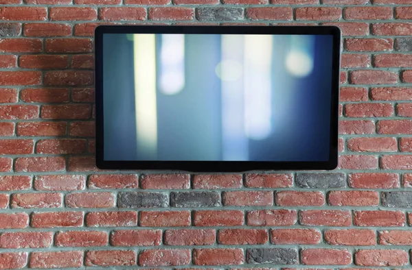 Telewizor na czerwonej ścianie z cegły z abstrakcyjnym Splash na ekranie — Zdjęcie stockowe