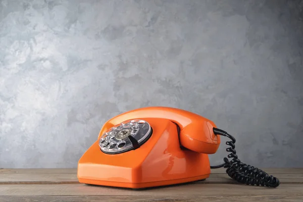 Vintage oranje telefoon op betonnen muur achtergrond — Stockfoto