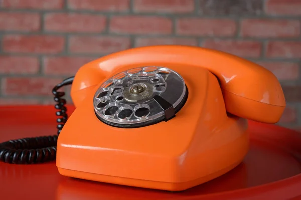 Telefone laranja vintage no fundo vermelho — Fotografia de Stock
