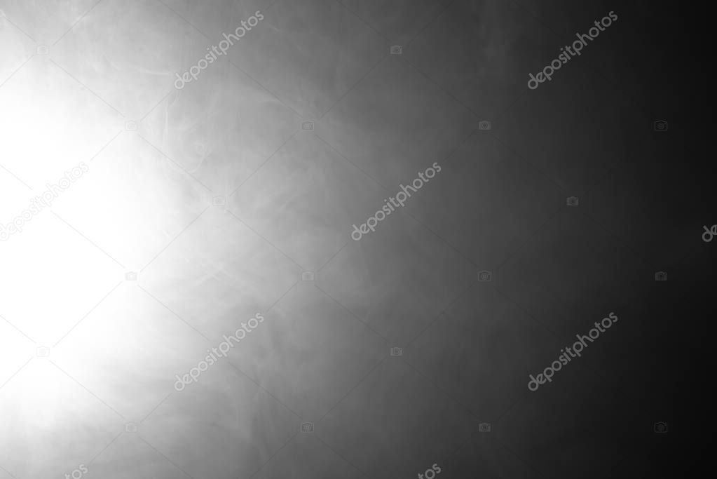 Smoke on a black background in the spotlight