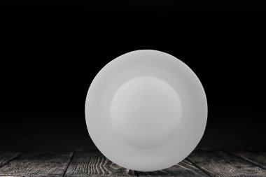 siyah bir arka plan üzerinde beyaz tabak