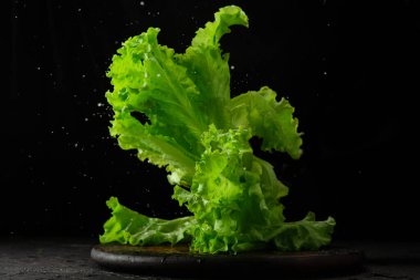 Siyah arkaplanda bir masada marul