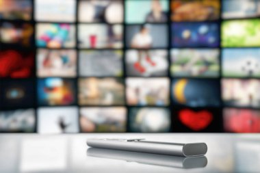 Büyük bir TV ekranının arka planında televizyondan uzaktan kumanda