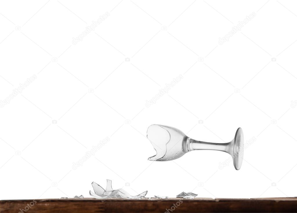 Broken wine glass on a table behind an isolated background