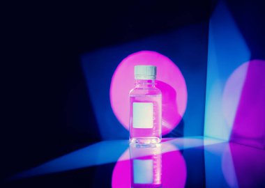 Soyut arkaplanda sıvı bulunan küçük şişe