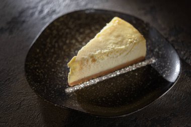 Siyah tabakta taze peynirli kek.