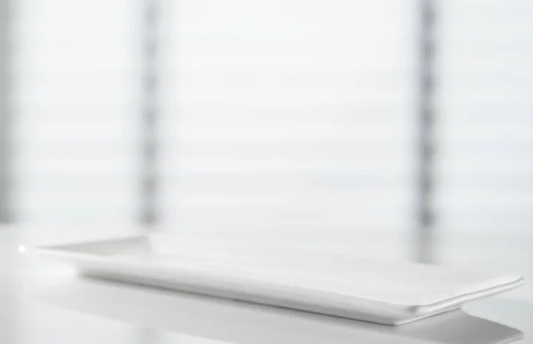 白いキッチンテーブルの上の白い長方形のプレート — ストック写真