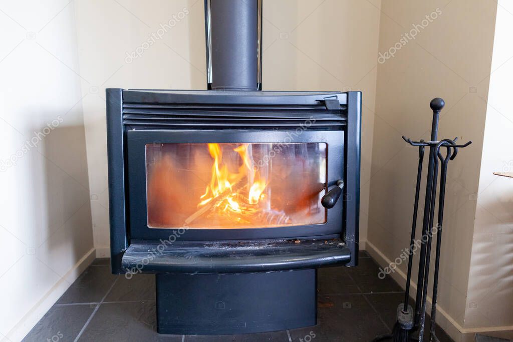 Wood burning in a fireplace to warm the house.