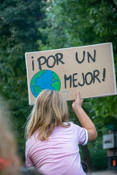 Ein Mädchen hält ein Banner mit dem Motto "Für eine bessere Welt" in die Höhe. — Stockfoto