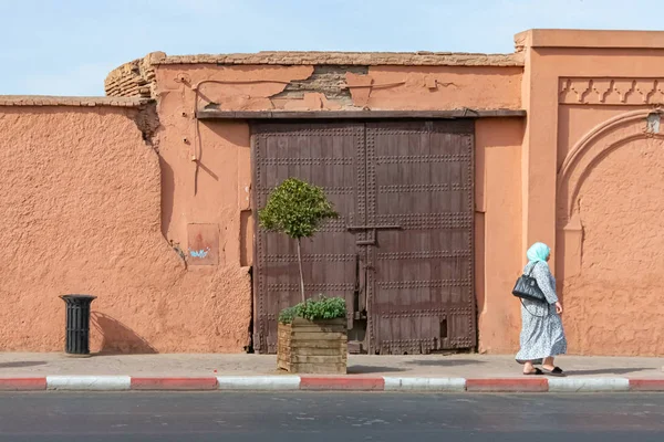 Mulher árabe e porta de madeira na cidade de Marrakech. Marrocos outubro 2019 — Fotografia de Stock