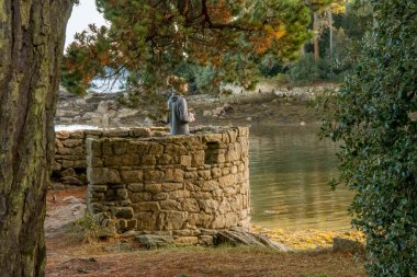 Morbihan Körfezi 'ndeki Bender Adası' nda taş kuledeki adam. Fransa Ekim 2018