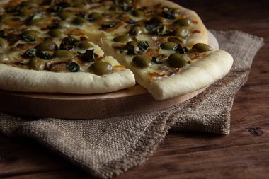 Ahşap bir masada mantar ve zeytin ile Pizza