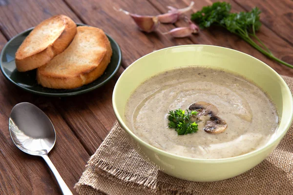 Mushroom cream soup with croutons and garlic on a wooden table. — Stock Image Mushroom cream soup with croutons and garlic on a wooden table. Stock Photo
