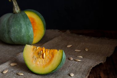 Tahta bir masada dilimlenmiş yeşil balkabağı.