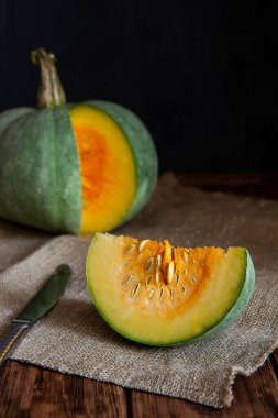 Tahta bir masada dilimlenmiş yeşil balkabağı.