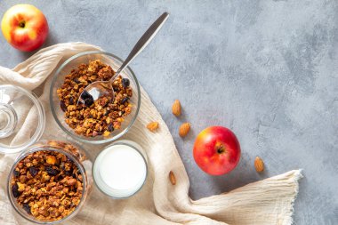 Elmalı ve tarçınlı granola gri arka planda cam bir kasede