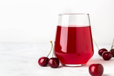Şeffaf bir bardakta vişne ezmesi ve hafif bir arka planda böğürtlen. Boşluğu kopyala