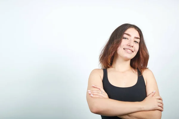 Mooi meisje in zwarte tank top over geïsoleerde witte achtergrond toont emoties — Stockfoto