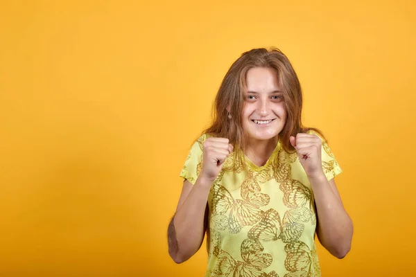 Brunette flicka i gul t-shirt över isolerade orange bakgrund visar känslor — Stockfoto