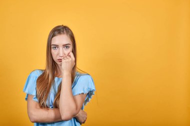izole turuncu arka plan üzerinde mavi t-shirt kız esmer duyguları gösterir