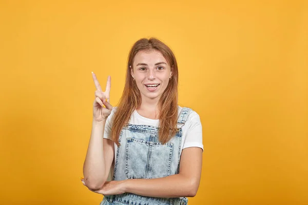 Mujer joven vistiendo camiseta blanca, sobre fondo naranja muestra emociones —  Fotos de Stock