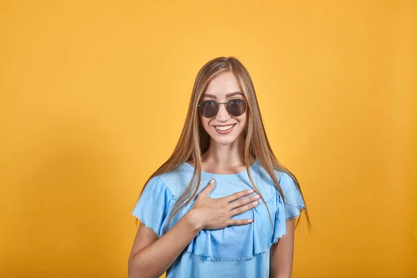 Girl brunette in blue t-shirt over isolated orange background shows emotions — Stock Photo, Image