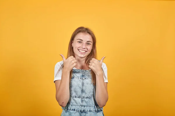 Mujer joven vistiendo camiseta blanca, sobre fondo naranja muestra emociones —  Fotos de Stock