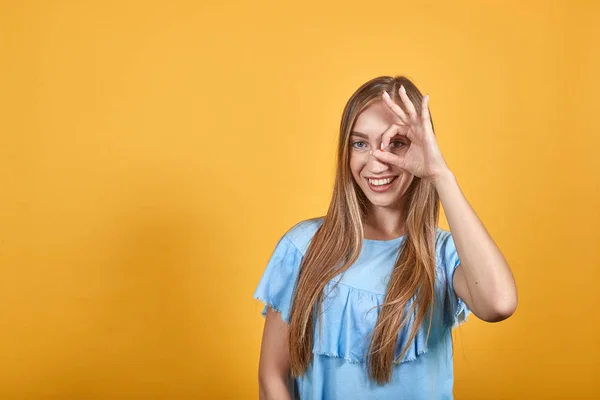 Girl brunette in blue t-shirt over isolated orange background shows emotions — Stock Photo, Image